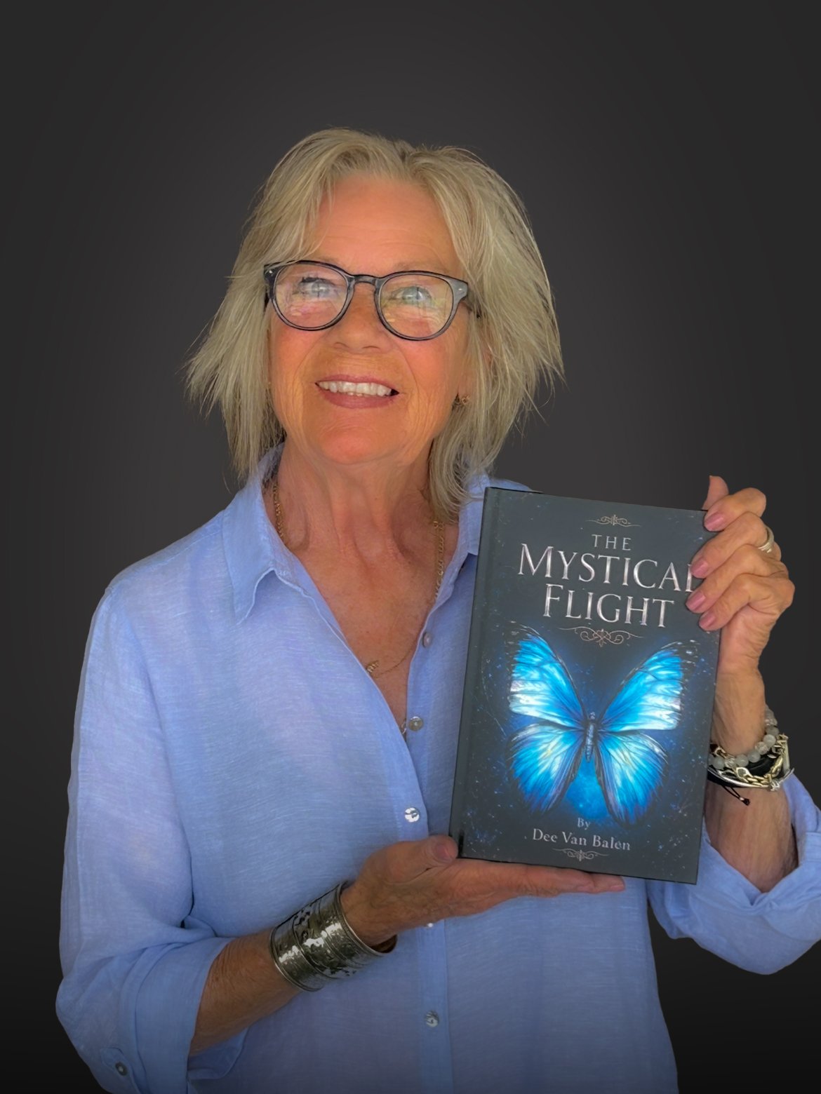 Dee Van Balen, author of The Mystical Flight, holding a copy of her book